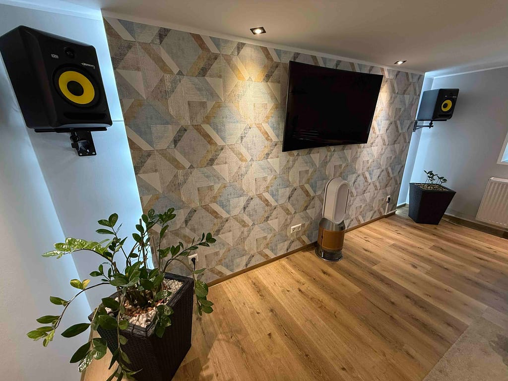 Moderner Raum mit Fernseher und Lautsprechern an der Wand.