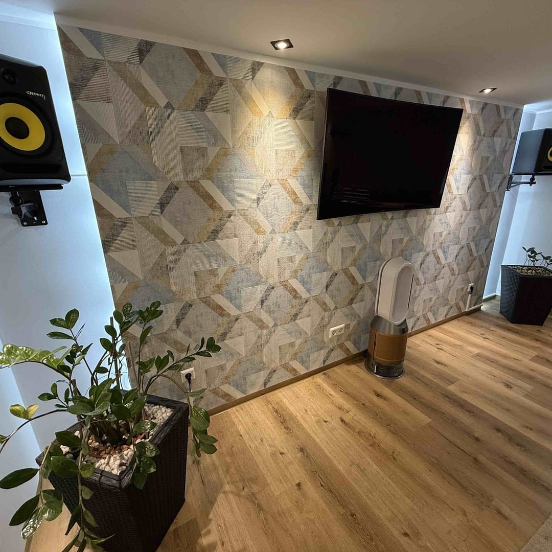 Moderner Raum mit Fernseher und Lautsprechern an der Wand.